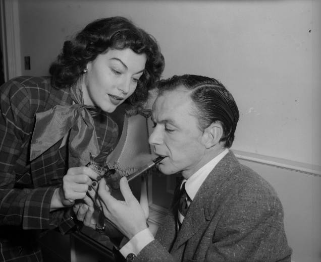 A atriz Ava Gardner ajuda seu marido, Frank Sinatra, a acender seu cachimbo - 11/12/1951 A atriz Ava Gardner ajuda seu marido, Frank Sinatra, a acender seu cachimbo - 11/12/1951