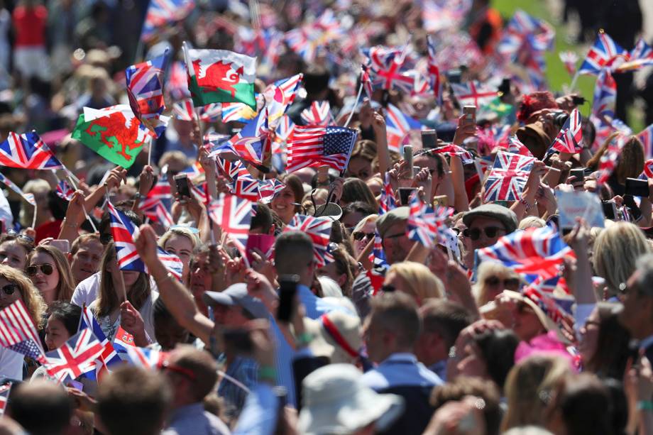 Multidão se aglomera nos arredores do Castelo de Windsor para acompanhar a passagem da carruagem os duques de Sussex - 19/05/2018