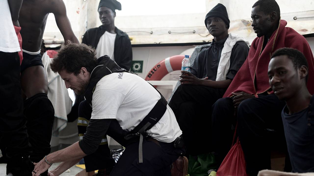 Migrantes sentam-se no convés do MV Aquarius, após resgate no Mar Mediterrâneo - 12/06/2018