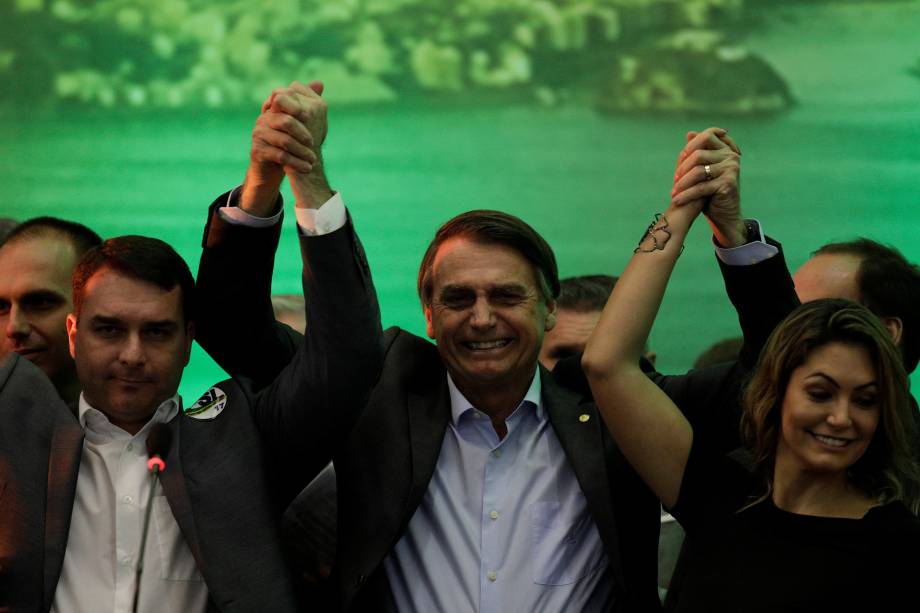O deputado federal Jair Bolsonaro levanta as mãos com seu filho Flavio Bolsonaro e sua esposa Michelle Bolsonaro durante convenção nacional do PSL, em que foi formalizado como candidato à Presidência da República, no Rio de Janeiro - 22/07/2018 O deputado federal Jair Bolsonaro levanta as mãos com seu filho Flavio Bolsonaro e sua esposa Michelle Bolsonaro durante convenção nacional do PSL, em que foi formalizado como candidato à Presidência da República, no Rio de Janeiro - 22/07/2018