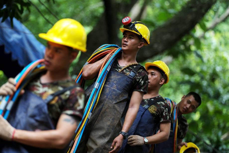 Soldados tailandeses carregam cabos para auxiliar no resgate dos 12 jovens jogadores de futebol e seu treinador, presos dentro de uma caverna inundada no complexo de Tham Luang, província de Chiang Rai, na Tailândia - 05/07/2018