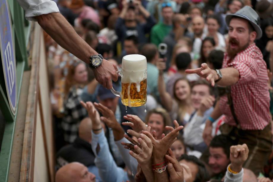 Visitantes se esforçam para alcançar uma caneca de cerveja durante a Oktoberfest de Munique, na Alemanha - 22/09/2018