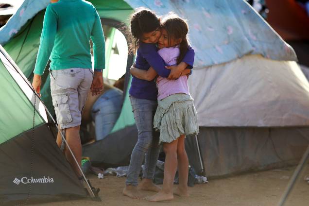 As crianças Vanessa e Seydi, de 7 anos de idade, se abraçam em acampamento improvisado montado por membros da caravana de imigrantes da América Central, próximo da fronteira entre o México e os Estados Unidos, na cidade de Tijuana - 27/11/2018 As crianças Vanessa e Seydi, de 7 anos de idade, se abraçam em acampamento improvisado montado por membros da caravana de imigrantes da América Central, próximo da fronteira entre o México e os Estados Unidos, na cidade de Tijuana - 27/11/2018