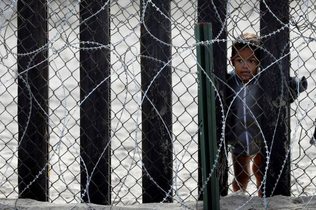 Criança observa através da fronteira entre o México e os Estados Unidos, em San Diego, no estado americano da Califórnia - 28/11/2018 Criança observa através da fronteira entre o México e os Estados Unidos, em San Diego, no estado americano da Califórnia - 28/11/2018