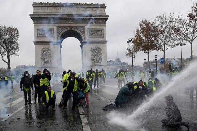 Manifestantes vestindo coletes amarelos, um símbolo de um protesto de motoristas franceses contra impostos mais altos no diesel, enfrentam a polícia de choque francesa durante os confrontos na Place de l'Etoile, perto do Arco do Triunfo, em Paris - 01/12/2018 Manifestantes vestindo coletes amarelos, um símbolo de um protesto de motoristas franceses contra impostos mais altos no diesel, enfrentam a polícia de choque francesa durante os confrontos na Place de l'Etoile, perto do Arco do Triunfo, em Paris - 01/12/2018