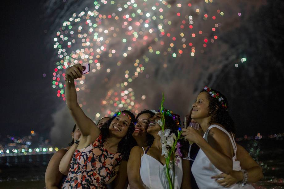 Mulheres tiram selfie com queima de fogos ao fundo durante celebrações de Ano Novo na praia de Copacabana, Rio de Janeiro - 01/01/2019