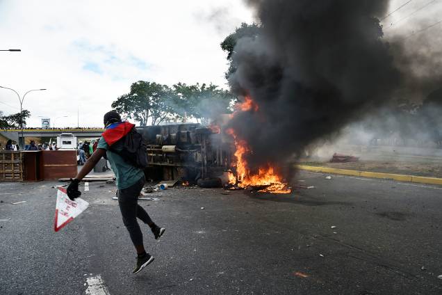 Veículo é incendiado durante marcha contra o governo do presidente venezuelano Nicolás Maduro, em Caracas - 23/01/2019 Veículo é incendiado durante marcha contra o governo do presidente venezuelano Nicolás Maduro, em Caracas - 23/01/2019
