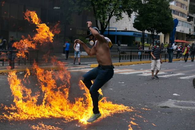 Manifestante salta sobre fogo durante protesto contra o governo do presidente venezuelano Nicolás Maduro, em Caracas - 23/01/2019 Manifestante salta sobre fogo durante protesto contra o governo do presidente venezuelano Nicolás Maduro, em Caracas - 23/01/2019