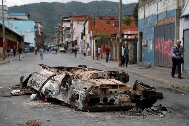 Um carro queimado durante os protestos contra o governo de Nicolas Maduro em Caracas, na Venezuela, é visto no meio da rua - 24/01/2019 Um carro queimado durante os protestos contra o governo de Nicolas Maduro em Caracas, na Venezuela, é visto no meio da rua - 24/01/2019