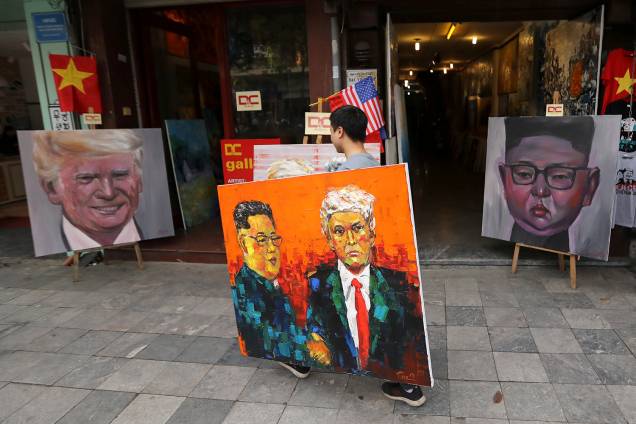 Um homem que carrega uma pintura de Donald Trump e Kim Jong-un passa em frente a outras duas pinturas dos líderes de EUA e Coréia do Norte, antes da cúpula que acontecerá em Hanói, no Vietnã - 27/02/2019 Um homem que carrega uma pintura de Donald Trump e Kim Jong-un passa em frente a outras duas pinturas dos líderes de EUA e Coréia do Norte, antes da cúpula que acontecerá em Hanói, no Vietnã - 27/02/2019