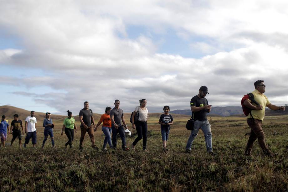 Pessoas andando em fila tentam atravessar a fronteira fechada entre Brasil e Venezuela em Pacaraima, estado de Roraima - 22/02/2019