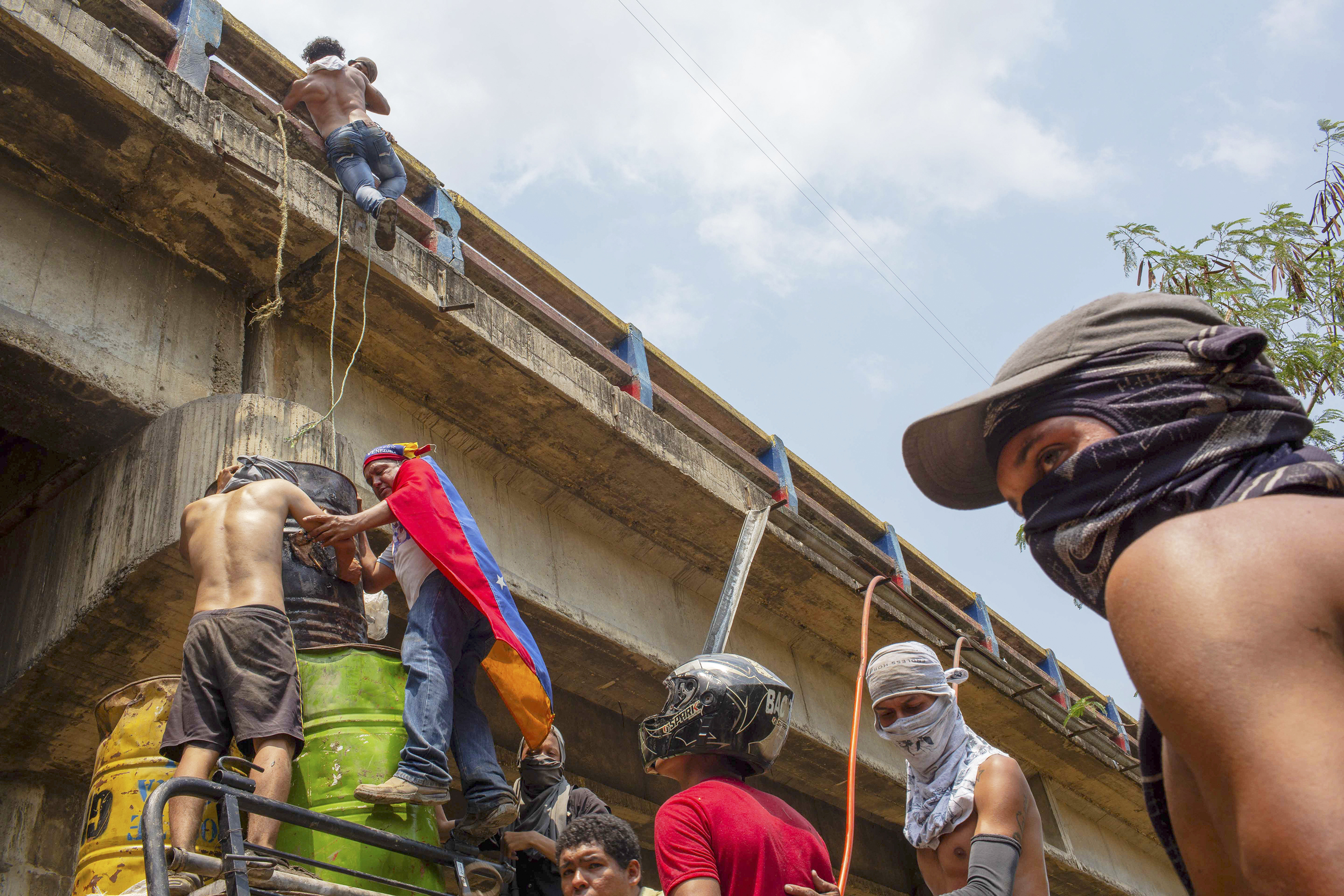 Manifestantes em Cúcuta, na Colômbia Jovens improvisam uma escada para subir na Ponte Francisco de Paula Santander, que liga as cidades de Cúcuta, na Colômbia, a Ureña, na Venezuela, para atacar soldados da Guarna Nacional Bolivariana