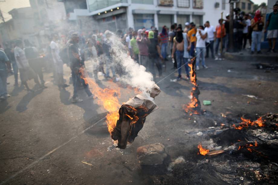 Manifestantes queimam uniforme da milícia durante confronto com as forças de segurança em Ureña, Venezuela - 23/02/2019 Manifestantes queimam uniforme da milícia durante confronto com as forças de segurança em Ureña, Venezuela - 23/02/2019