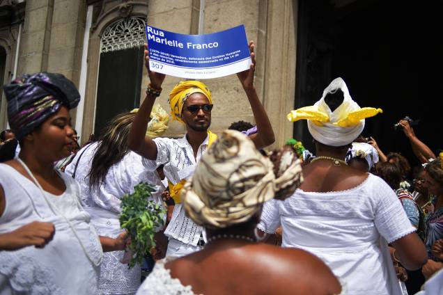 Pessoas vestidas com trajes de religiões afro-brasileiras prestam homenagens à vereadora Marielle Franco em frente à Igreja da Candelária, no Rio de Janeiro - 14/03/2019 Pessoas vestidas com trajes de religiões afro-brasileiras prestam homenagens à vereadora Marielle Franco em frente à Igreja da Candelária, no Rio de Janeiro - 14/03/2019