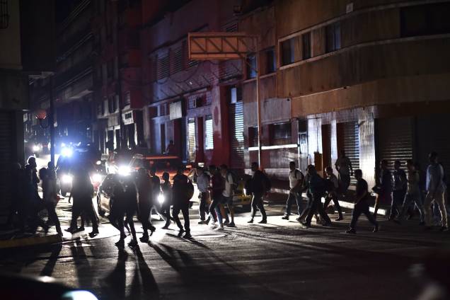 Pessoas atravessam uma rua durante um corte de energia em Caracas. O governo de Nicolás Maduro aponta "sabotagem" contra a principal represa de energia elétrica no país - 07/03/2019 Pessoas atravessam uma rua durante um corte de energia em Caracas. O governo de Nicolás Maduro aponta "sabotagem" contra a principal represa de energia elétrica no país - 07/03/2019