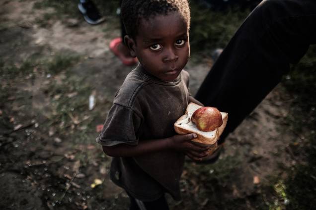 Garoto recebe alimentos em um centro de distribuição de um supermercado em Dondo, cerca de 35 km ao norte de Beira, cidade que ficou destruída após passagem do ciclone Idai em Moçambique - 27/03/2019 Garoto recebe alimentos em um centro de distribuição de um supermercado em Dondo, cerca de 35 km ao norte de Beira, cidade que ficou destruída após passagem do ciclone Idai em Moçambique - 27/03/2019