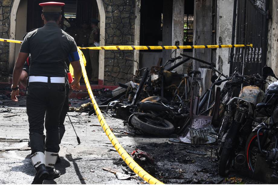 Policial passa ao lado de motocicletas destruídas do lado de fora da Igreja Zion, após uma explosão em Batticaloa, no leste do Sri Lanka - 21/04/2019