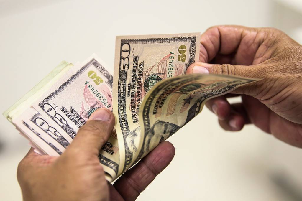 Dólar cai após suspensão de ‘tarifaço’; Ibovespa recua com aumento do IOF