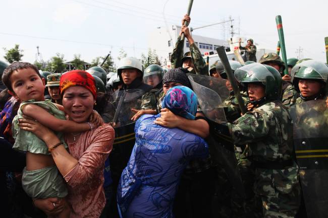 Policiais chineses empurram mulheres da etnia uigur durante protesto em Urumqi, capital da região autônoma de Xinjiang – 07/07/2009