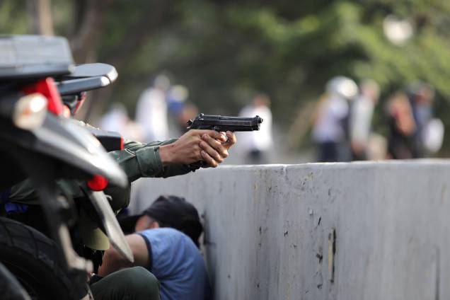Militar aponta uma arma durante manifestações nos arredores da Base Aérea "La Carlota", em Caracas, na Venezuela - 30/04/2019 Militar aponta uma arma durante manifestações nos arredores da Base Aérea "La Carlota", em Caracas, na Venezuela - 30/04/2019