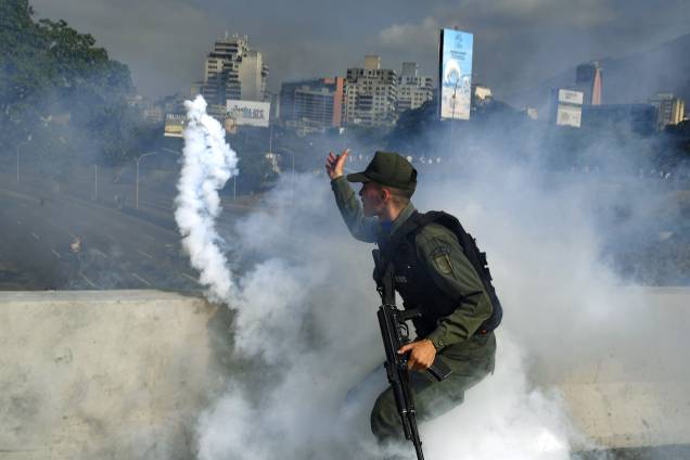 Membro da Guarda Nacional Bolivariana apoiador do líder de oposição Juan Guaidó lança uma bomba de gás lacrimogêneo durante confronto com forças leais ao governo do presidente Nicolas Maduro em frente à base militar de La Carlota em Caracas - 30/04/2019 Membro da Guarda Nacional Bolivariana apoiador do líder de oposição Juan Guaidó lança uma bomba de gás lacrimogêneo durante confronto com forças leais ao governo do presidente Nicolas Maduro em frente à base militar de La Carlota em Caracas - 30/04/2019