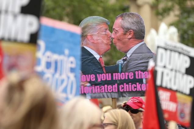 Manifestantes exibem um cartaz com o presidente dos Estados Unidos, Donald Trump, e o líder do partido Brexit, Nigel Farage, durante manifestação contra a visita de Trump em Londres - 04/06/2019 Manifestantes exibem um cartaz com o presidente dos Estados Unidos, Donald Trump, e o líder do partido Brexit, Nigel Farage, durante manifestação contra a visita de Trump em Londres - 04/06/2019