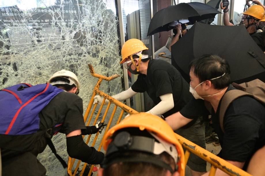 Manifestantes destroem portas e janelas de vidro do prédio do Conselho Legislativo durante o aniversário da transferência de Hong Kong para a China, em Hong Kong - 01/07/2019