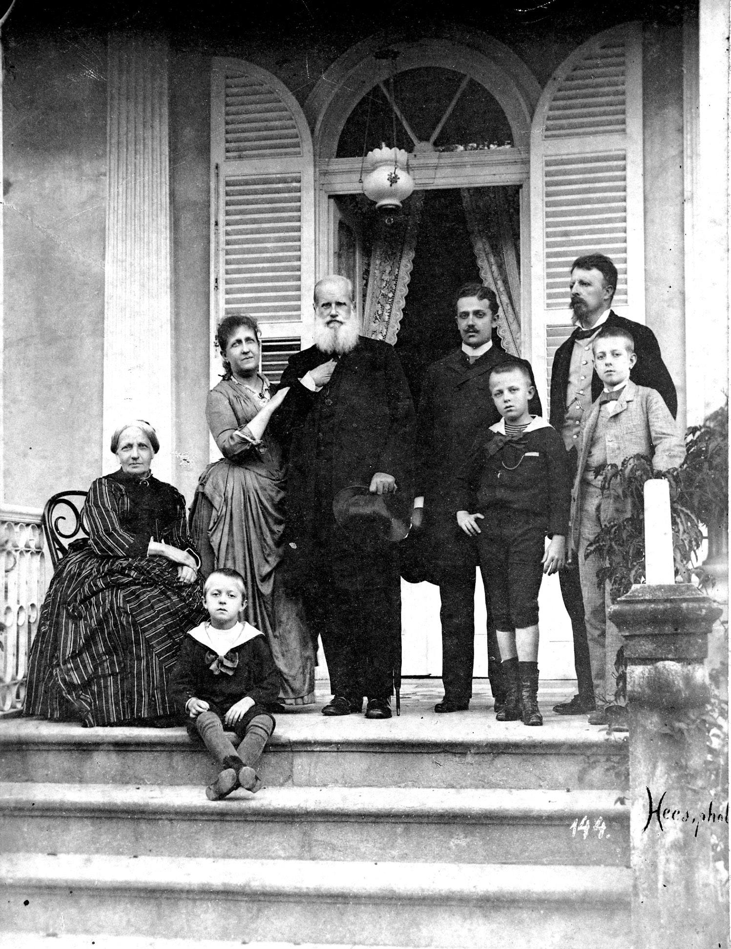 A Família Imperial na varanda da residência da princesa Isabel e do conde d’Eu, em Petrópolis, hoje Casa da Princesa. Da esquerda para a direita: d. Teresa Cristina, sentada, a princesa Isabel, de braços dados com d. Pedro II, d. Pedro Augusto e o conde d’Eu, todos em pé. Na frente, d. Luís e d. Pedro, príncipe do Grão-Pará. No degrau da escada, d. Antônio, sentado, aos pés de sua avó. Circa 1889