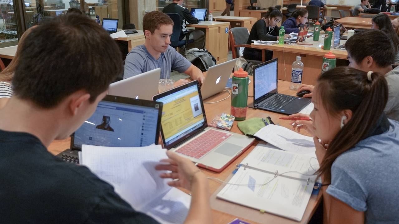 Jovens estudam em biblioteca