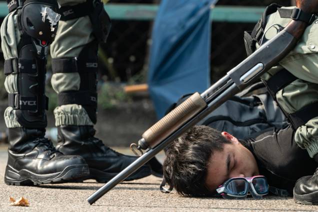 Um manifestante é detido pela polícia enquanto tenta escapar da Universidade Politécnica de Hong Kong Um manifestante é detido pela polícia enquanto tenta escapar da Universidade Politécnica de Hong Kong