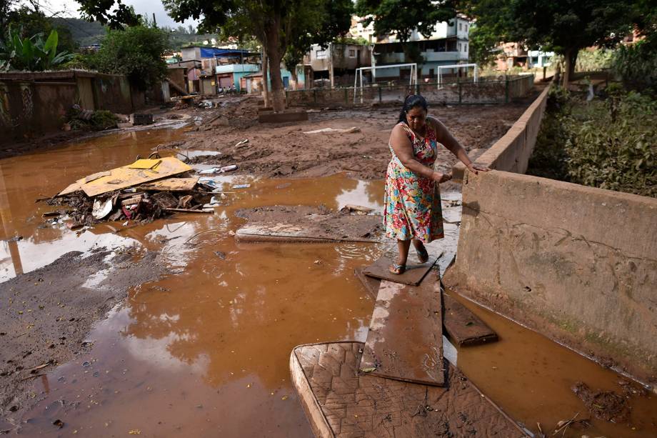 Um morador local caminha em uma rua alagada após o transbordamento do córrego Da Prata devido a chuvas torrenciais, em Raposos, região metropolitana de Belo Horizonte, em 28 de janeiro