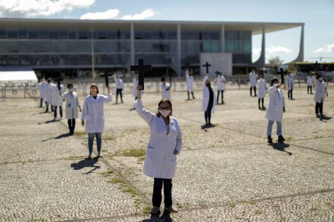 Nurses wearing protective face masks hold crosses during a symbolic protest and tribute for health workers on Labour Day, in Brasilia Nurses wearing protective face masks hold crosses during a symbolic protest and tribute for health workers on Labour Day, in Brasilia