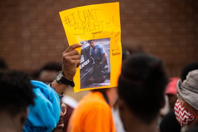Um manifestante segura uma placa, mostrando uma imagem do vídeo da prisão de George Floyd, do lado de fora da Delegacia 3ª Delegacia em Minneapolis, Minnesota Um manifestante segura uma placa, mostrando uma imagem do vídeo da prisão de George Floyd, do lado de fora da Delegacia 3ª Delegacia em Minneapolis, Minnesota