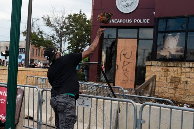 Um manifestante arremessa um pedaço de concreto no prédio da Delegacia de Polícia em Minneapolis, Minnesota Um manifestante arremessa um pedaço de concreto no prédio da Delegacia de Polícia em Minneapolis, Minnesota