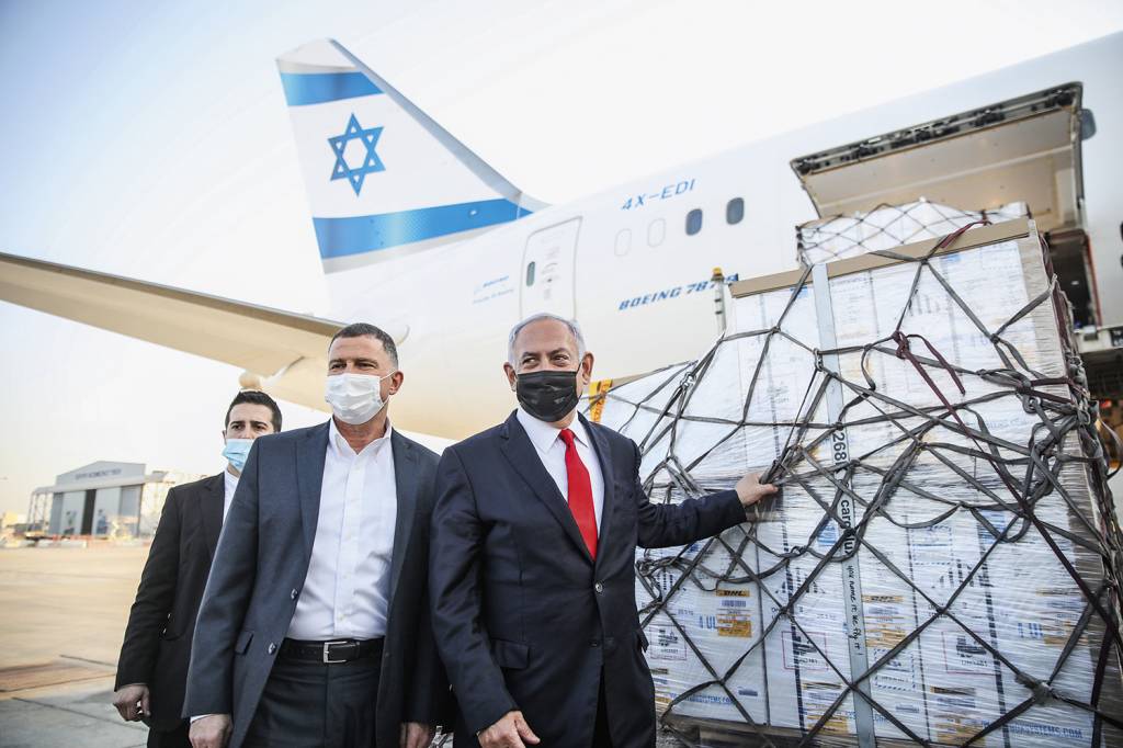 8013043928001.jpg EM CAMPANHA - Netanyahu (de máscara preta) recebe o primeiro lote de doses: triunfo político às vésperas da eleição -