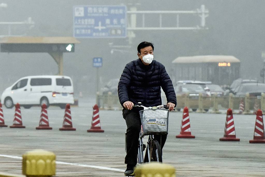 Air pollution in Beijing ATAQUE AOS PULMÕES - Ciclista em Pequim: morador pedala de máscara para se proteger da poluição -
