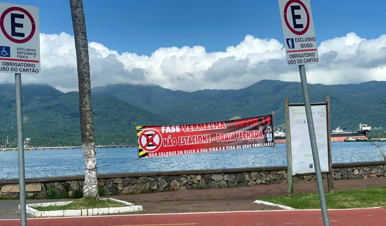 Faixa avisa que praia está interditada em São Sebastião, litoral de São Paulo, em razão da fase vermelha