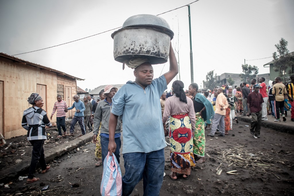 Residents are seen gathering in a busy street after an eruption from Mount Nyiragongo on May 23, 2021 in Goma in the East of the Democratic Republic of Congo. - A river of boiling lava came to a halt on the outskirts of Goma Sunday, sparing the city in eastern DR Congo from disaster after the nighttime eruption of Mount Nyiragongo sent thousands of terrified residents fleeing in panic.
