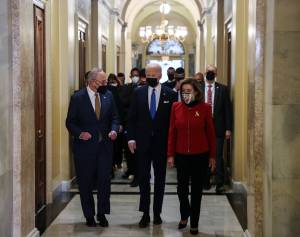 U.S. Capitol Commemorates First Anniversary Of January 6 Attack Presidente dos EUA, Joe Biden, caminha no Capitólio junto ao líder da maioria democrata no senado, Chuck Schumer, e presidente da Câmara, Nancy Pelosi. 06/01/2022