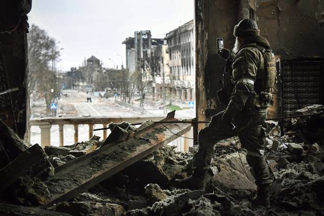 Um soldado russo patrulha o teatro dramático de Mariupol, bombardeado em 16 de março passado, em 12 de abril de 2022. - Um soldado russo patrulha o teatro dramático de Mariupol, bombardeado em 16 de março passado, em 12 de abril de 2022. -