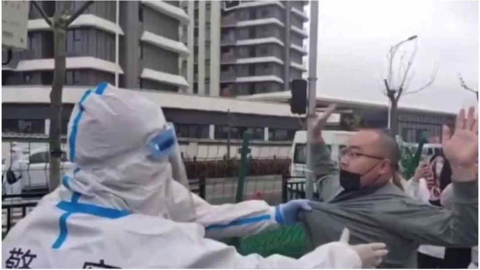 Video has emerged of clashes between police and people being forced out of their homes in Shanghai, as the city enters a third week of Covid lockdown