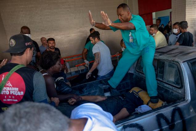 Uma mulher segura a mão de uma vítima que chega em uma caminhonete no Hospital Getulio Vargas - Uma mulher segura a mão de uma vítima que chega em uma caminhonete no Hospital Getulio Vargas -