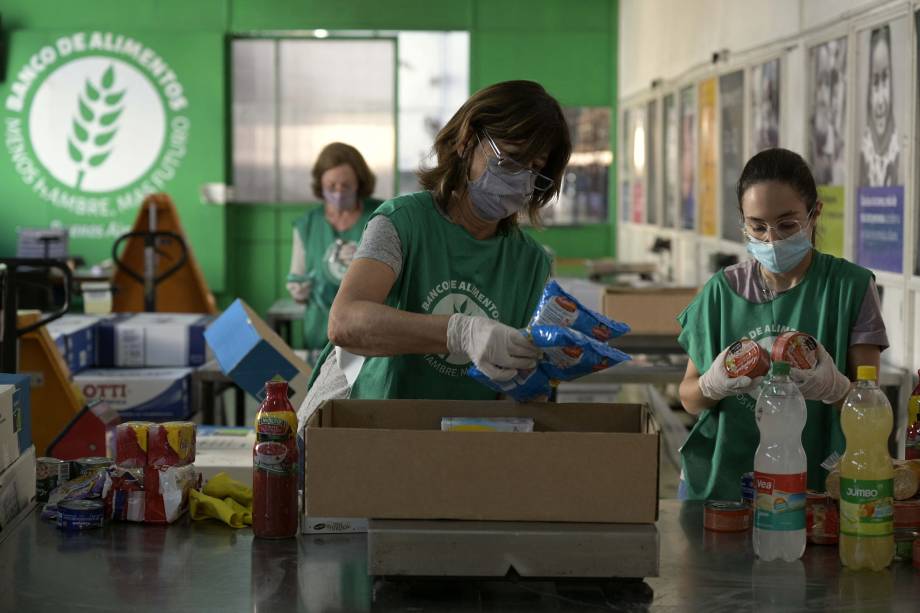 Voluntários selecionam alimentos doados no depósito do Banco de Alimentos em Munro, província de Buenos Aires, Argentina, em 20 de abril de 2022. - A inflação na Argentina, que há anos é uma das mais altas do mundo, aumentará ainda mais em 2022, considerando que os preços dos alimentos já subiram 20% no primeiro trimestre do ano. Mais de 4 milhões de pessoas dependem de subsídios estatais para se alimentar.