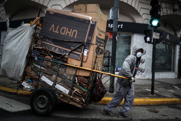 Um homem recolhendo papelão nas ruas de Buenos Aires para reciclagem. Um homem recolhendo papelão nas ruas de Buenos Aires para reciclagem.