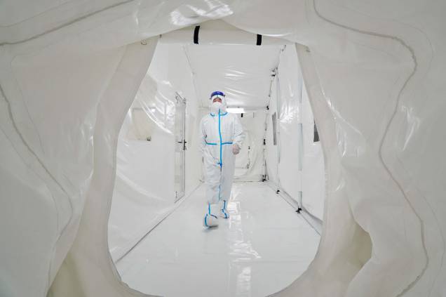 Foto de 17 de março de 2022, mostra um funcionário, usando equipamento de proteção individual, caminhando no laboratório Fire Eye, uma instalação temporária de testes de Coronavírus Covid-19 na província de Shandong, leste da China. Foto de 17 de março de 2022, mostra um funcionário, usando equipamento de proteção individual, caminhando no laboratório Fire Eye, uma instalação temporária de testes de Coronavírus Covid-19 na província de Shandong, leste da China.