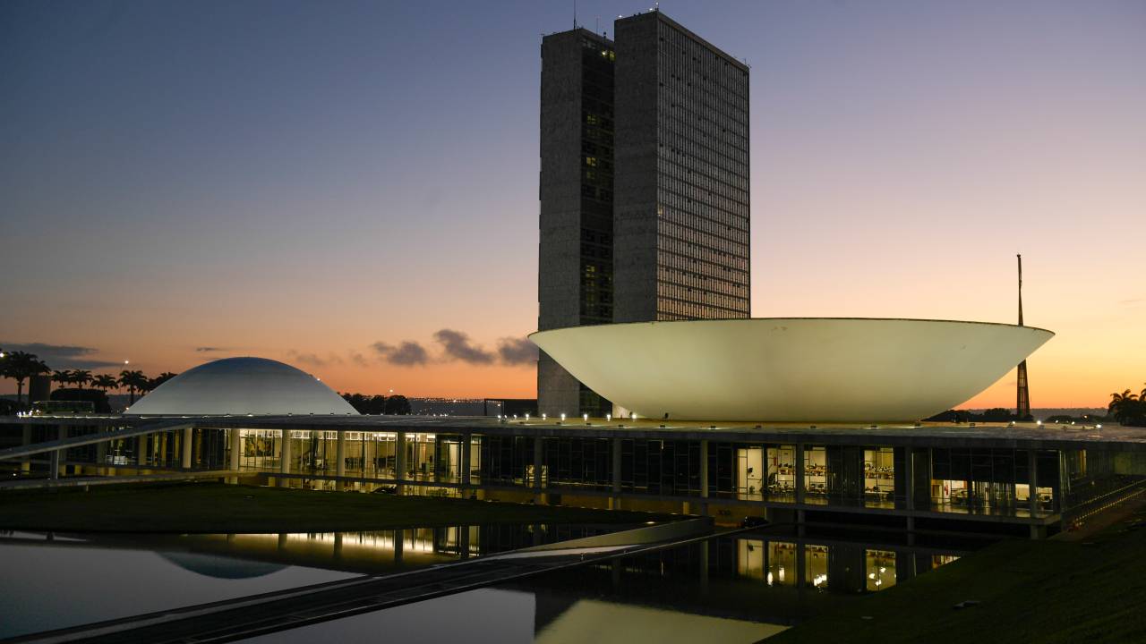 Fachada do Congresso Nacional, a sede das duas Casas do Poder Legislativo brasileiro, durante o amanhecer. As cúpulas abrigam os plenários da Câmara dos Deputados (côncava) e do Senado Federal (convexa), enquanto que nas duas torres - as mais altas de Brasília, com 100 metros - funcionam as áreas administrativas e técnicas que dão suporte ao trabalho legislativo diário das duas instituições. Obra do arquiteto Oscar Niemeyer