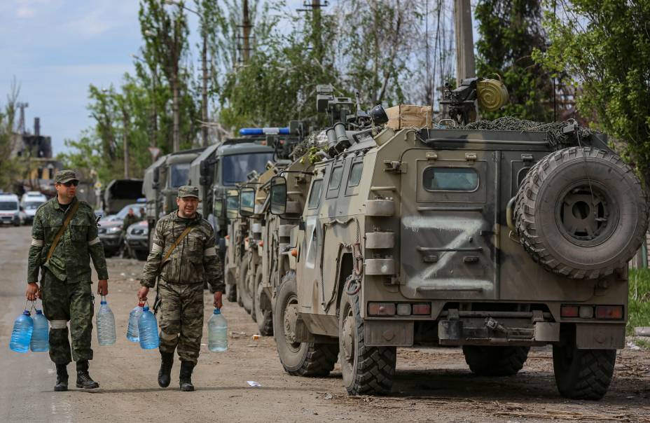 A autoproclamada milícia da República Popular de Donetsk, carregam garrafas de água enquanto a evacuação de militares ucranianos está sendo preparada  em Mariupol, Ucrânia, 17/05/2022. 