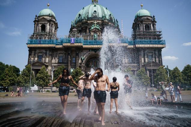 Turistas se refrescam em uma fonte no parque Lustgarten em Berlim, Alemanha, 19/06/2022. Turistas se refrescam em uma fonte no parque Lustgarten em Berlim, Alemanha, 19/06/2022.