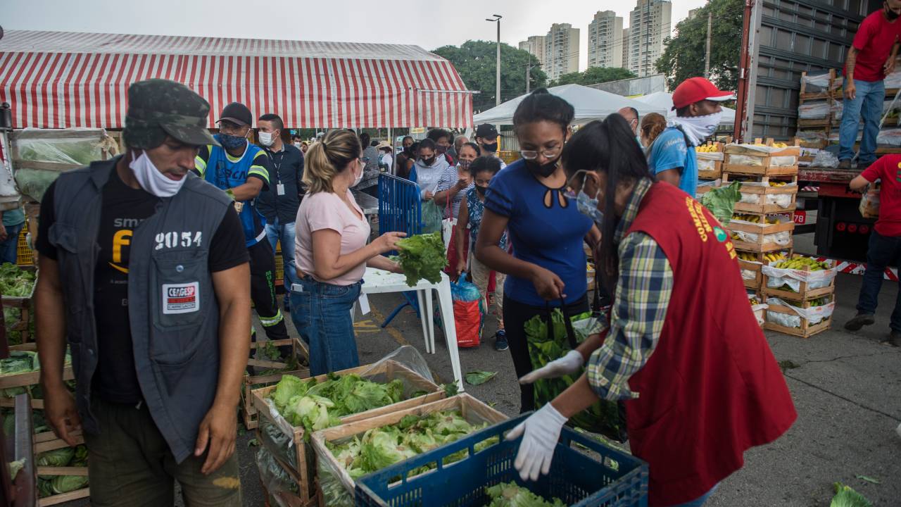 Pessoas durante distribuição de cestas de alimentos doadas por comerciantes da Ceagesp -