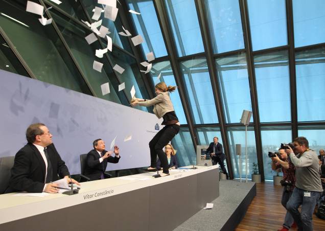 Protesto de uma mulher, durante uma entrevista coletiva de Mario Draghi, presidente do Banco Central Europeu, em Frankfurt na Alemanha. 15/04/2015. Protesto de uma mulher, durante uma entrevista coletiva de Mario Draghi, presidente do Banco Central Europeu, em Frankfurt na Alemanha. 15/04/2015.